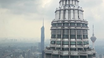 Petronas Towers in Kuala Lumpur bei bewölktem und grauem Himmel - Malaysia Familienreise