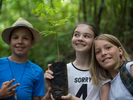 Drei Kinder bereiten Mini-Baum zum Pflanzen vor – Costa Rica Reise mit Kindern