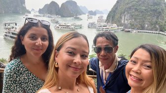 Tourguide nimmt Selfie mit Besucherinnen vor der Halong-Bucht – Vietnam Familienreise