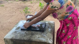Frau macht in der Nähe von Sigiriya ein traditionelles Gericht – Sri Lanka Familienreise