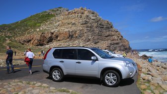 Geparktes Auto am Kap der Guten Hoffnung mit Blick auf das Meer – Garden Route Familienreise