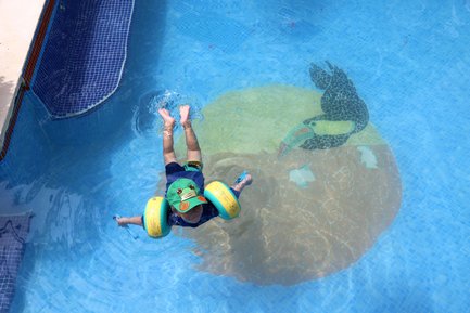 Kleinkind planscht fröhlich am Pool der Mawamba Lodge im Tortuguero Nationalpark – Costa Rica Familienreise