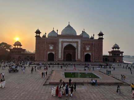 Die majestätische Taj Mahal strahlt im Sonnenuntergang, umgeben von Besuchern, die die Schönheit des Denkmals bewundern.