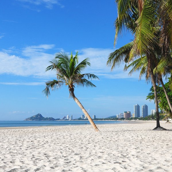 Sandstrand, Meer und Palmen mit Blick auf die Stadt Hua Hin - Thailand mit Kindern