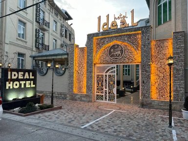 Der Eingangsbereich des Ideal Hotels zeigt eine kunstvoll gestaltete Fassade mit warmem Licht und einem eleganten Tor.