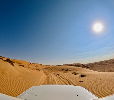 Geländewagen in der Wahiba-Wüste mit Sonnenlicht – Oman Familienreise