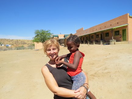 Eine Frau hat ein Kind auf dem Arm - Namibia mit Jugendlichen