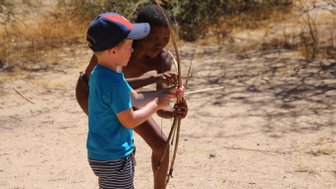 Ein Kind versucht einen Bogen zu spannen - Namibia Urlaub mit Kindern