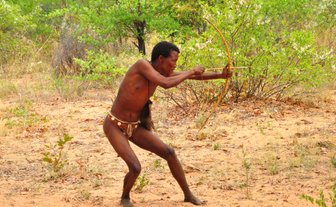 Ein Mann schießt mit einem kleinen Bogen - Namibia Urlaub mit Kindern
