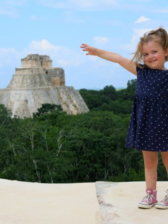 Kleines Mädchen lächelnd vor der Pyramide in Uxmal – Mexiko Familienreise