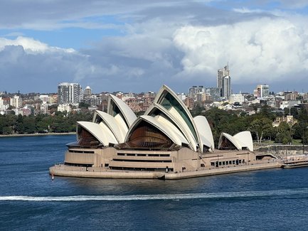 Das Sydney Opera House mit seinen ikonischen, segelartigen Dächern thront majestätisch über dem blauen Wasser des Hafens.