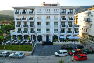 Das elegante Hotel Chimaera mit weißer Fassade und Balkonen bietet eine einladende Atmosphäre in einer malerischen Umgebung.