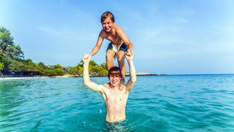 Kinder spielen im klaren Wasser am Strand von Koh Samet – Thailand Familienreise