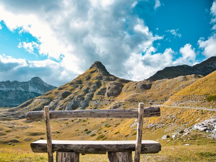 Eine einsame Bank steht alleine in der Natur mit einem traumhaften Blick in die Ferne