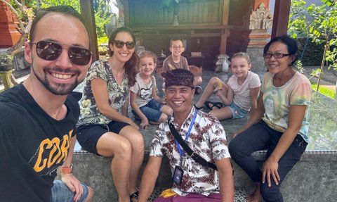 Familie posiert fröhlich für ein Selfie mit ihrem Reiseleiter – Bali mit Kindern