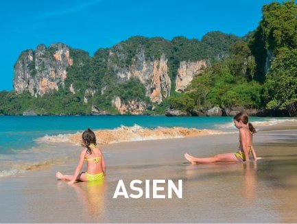Zwei Kinder sitzen am Strand, während sanfte Wellen an die Küste schlagen, umgeben von beeindruckenden Felsen.
