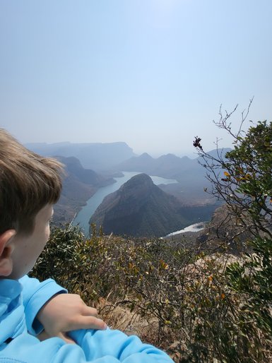 Ein Kind steht am Rand des Blyde River Canyons und blickt fasziniert auf die Landschaft – Südafrika mit Kindern
