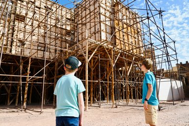 Kinder schauen neugierig auf die Filmkulissen der Atlas Film Studios in Marokko – Familienurlaub in Marokko