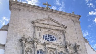 Die beeindruckende Fassade der Igreja de São Domingos zeigt kunstvolle Statuen und eine große Eingangstür mit rotem Vorhang.
