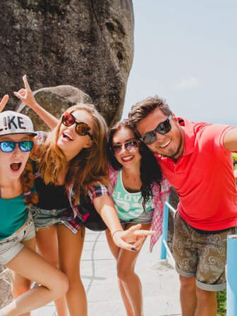 Jugendliche halten fröhlich ein Selfie vor der Dschungellandschaft – Thailand Familienreise