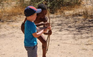 Ein Kind versucht einen Bogen zu spannen - Namibia Urlaub mit Kindern