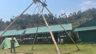 Ein Junge schwingt fröhlich auf einer großen Schaukel, während ein Erwachsener ihn anfeuert, umgeben von einer malerischen Landschaft.