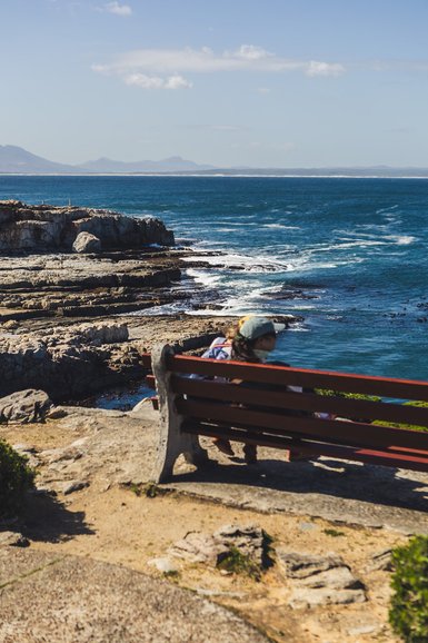 Kindern genießen die Aussicht auf einer Bank in Hermanus – Südafrika Familienreise