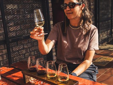 Frau trinkt ein Glas Wein in der Garden Route – Südafrika mit Kindern