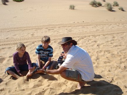 Zwei Kinder und ein Mann sitzen im Sand - Namibia Familienurlaub