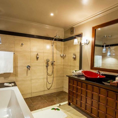 Ein modernes Badezimmer mit einer freistehenden Badewanne und einer eleganten Dusche, die durch Glaswände abgetrennt ist.