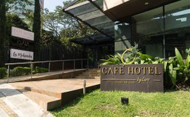 Der Eingangsbereich des Café Hotels in Medellín zeigt eine moderne Architektur mit einer einladenden Treppe und Pflanzen.