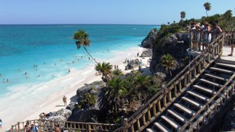 Holzstufen führen hinab zum kristallklaren Strand von Tulum – Mexiko Reise mit Kindern