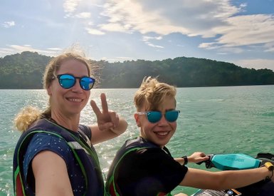 Mutter fährt mit ihrem Kind auf einem Jetski über das Meer vor Langkawi – Malaysia & Borneo Familienreise