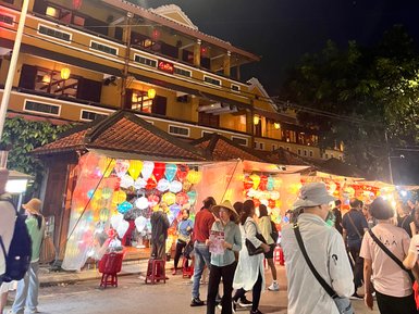 Belebter Nachtmarkt mit Ständen und Lichtern in Hoi An – Vietnam Familienreise