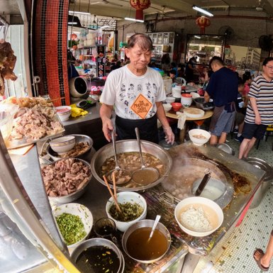 Streetfood-Verkäufer bereitet dampfende Suppe frisch auf einem Markt in Kuala Lumpur zu – Malaysia & Borneo Reise mit Kindern