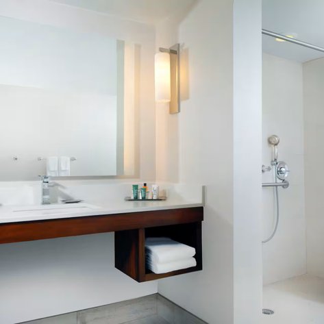 Ein modernes Badezimmer mit einem eleganten Waschbecken und einem großen Spiegel, ergänzt durch sanfte Beleuchtung.