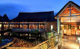 Ein stilvolles Lodge-Gebäude mit Holzverkleidung und einem einladenden Eingangsbereich, umgeben von sanften Lichtverhältnissen.