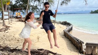 Geschwister schaukeln gemeinsam am Strand des Nexus Resorts – Malaysia & Borneo Familienreise