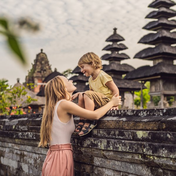 Mutter und Kind besuchen einen traditionellen balinesischen Tempel – Bali Familienreise