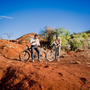 Paar fährt gemeinsam auf Basahy-Fahrrädern durch die Landschaft – Tansania Familienreise
