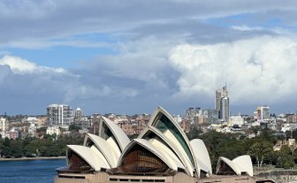 Das Sydney Opera House mit seinen ikonischen, segelartigen Dächern thront majestätisch über dem blauen Wasser des Hafens.