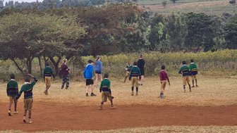 Reisende Kinder spielen gemeinsam mit einheimischen Schulkindern – Tansania Familienreise