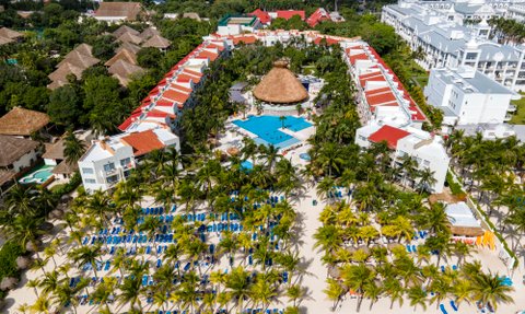 Ein weitläufiger Blick auf das Viva Wyndham Azteca Resort, umgeben von üppigen Palmen und einem einladenden Poolbereich.