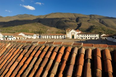 Die Aussicht zeigt die charmante Architektur von Villa de Leyva, umgeben von majestätischen Bergen und einem klaren blauen Himmel.