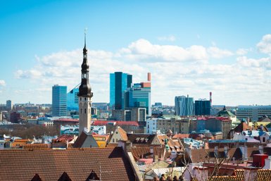 Die Skyline von Tallinn zeigt eine Mischung aus historischen und modernen Gebäuden unter einem strahlend blauen Himmel.