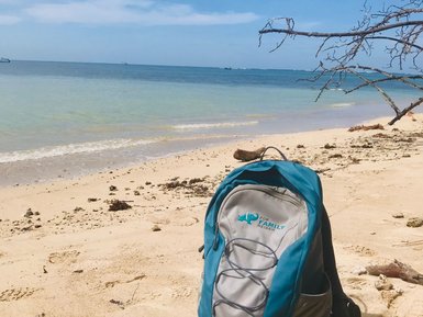 FFR Rucksack liegt im Schatten am weißen Sandstrand von Cahuita – Costa Rica Familienreise