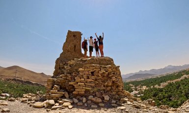 Familie steht oben auf einem Felsenhaus im Dorf Birkat Al Mauz – Oman mit Kindern