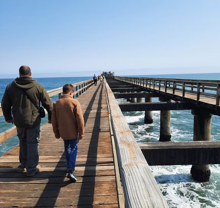 Zwei Menschen laufen einen langen Bootssteg entlang - Namibia mit Jugendlichen