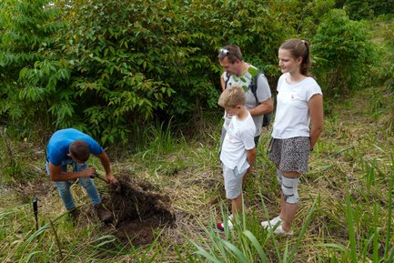 Guide unterstützt Familie beim Baum Pflanzen – Costa Rica mit Kindern