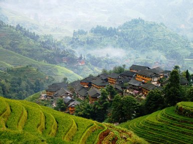Panorama der Reisterrassen von Longsheng mit Blick auf traditionelle Holzhäuser – China Familienreise